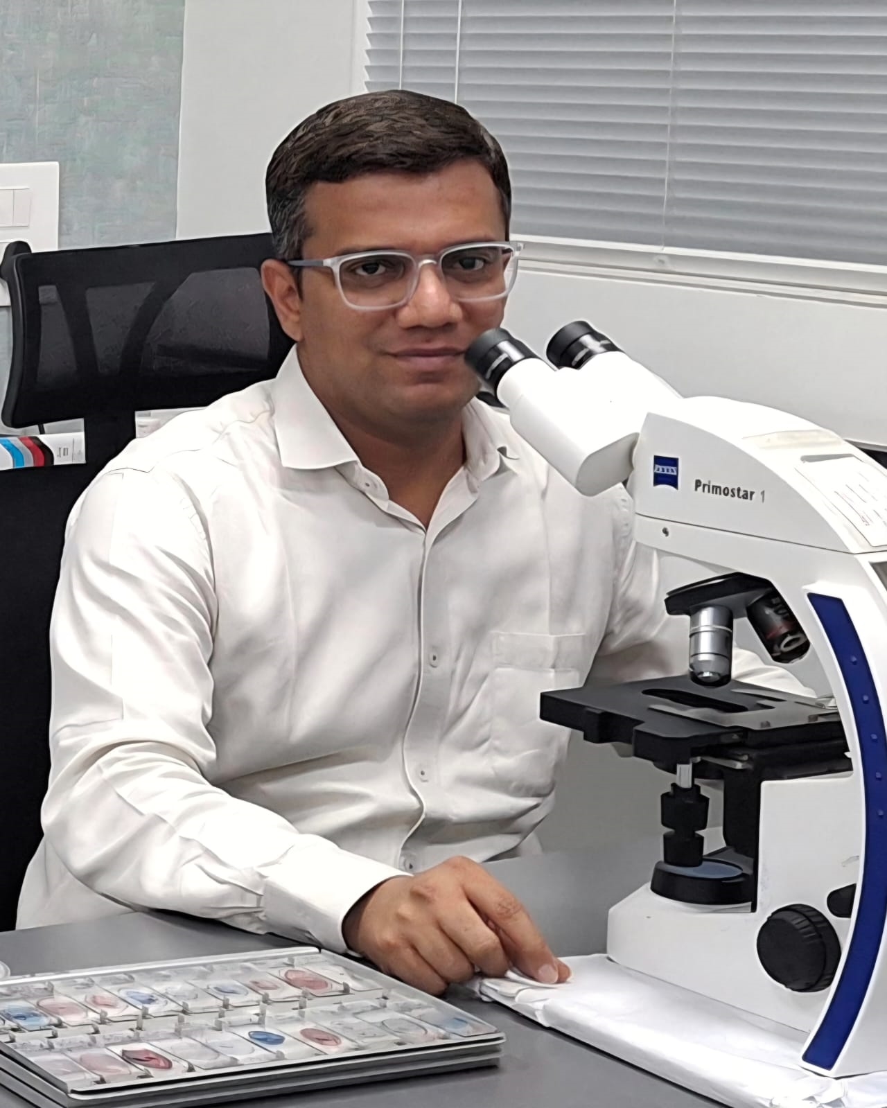Dr. Nirav Pandya, MD (Microbiology), CIC®, at the microscope in the laboratory
